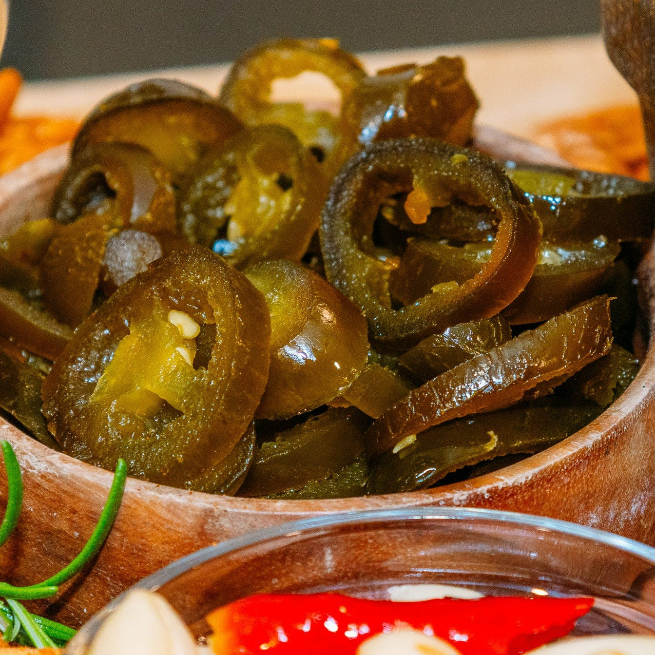 Candied Jalapenos in wooden bowl on graze or charcuterie board