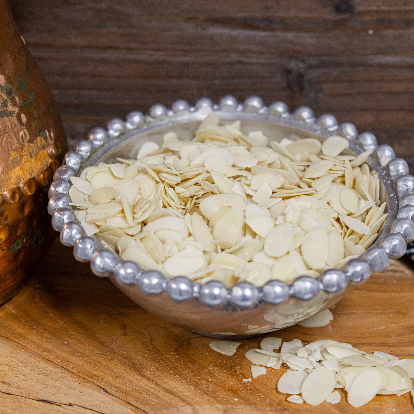 Thin sliced raw almonds in pewter beaded bowl