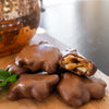 Ellis Bros Pecans milk chocolate almond turtles with caramel on wooden board