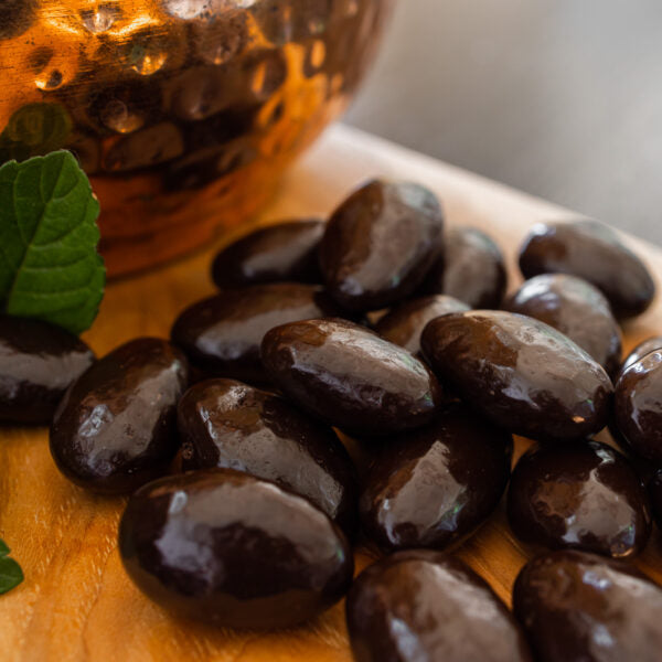 Dark chocolate almonds on wooden board